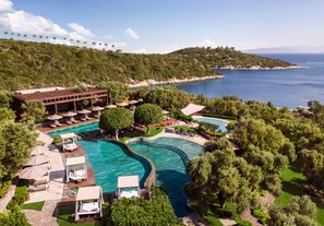 An aerial view of a resort with a large swimming pool, lounge areas, and a view of the sea. - Mandarin Oriental, Bodrum (Bodrum)