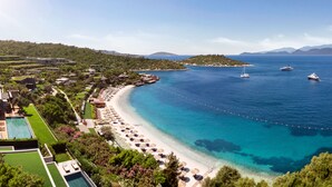 A coastal resort with a beach, clear blue waters, and boats.