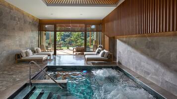 Relax by the rectangular pool surrounded by lounge areas with cushioned seating and wooden tables.