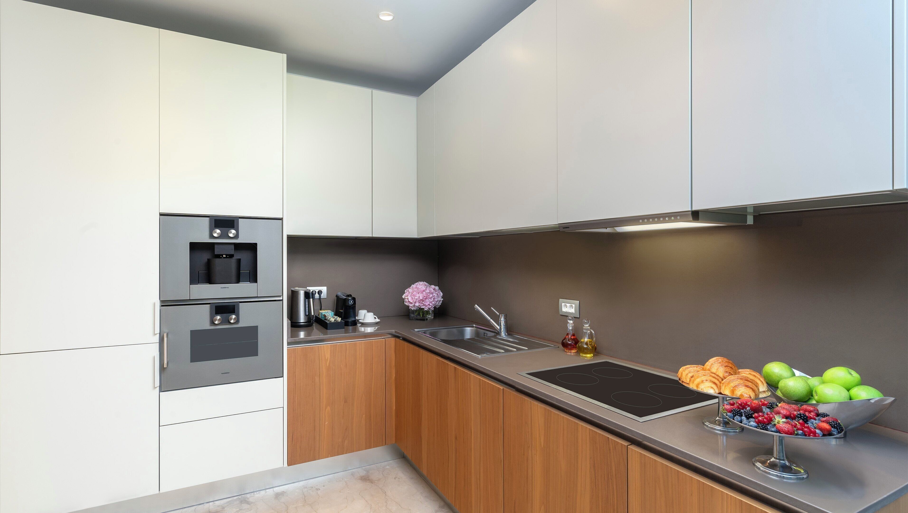 Una cocina moderna con electrodomésticos integrados, un fregadero y un frutero.