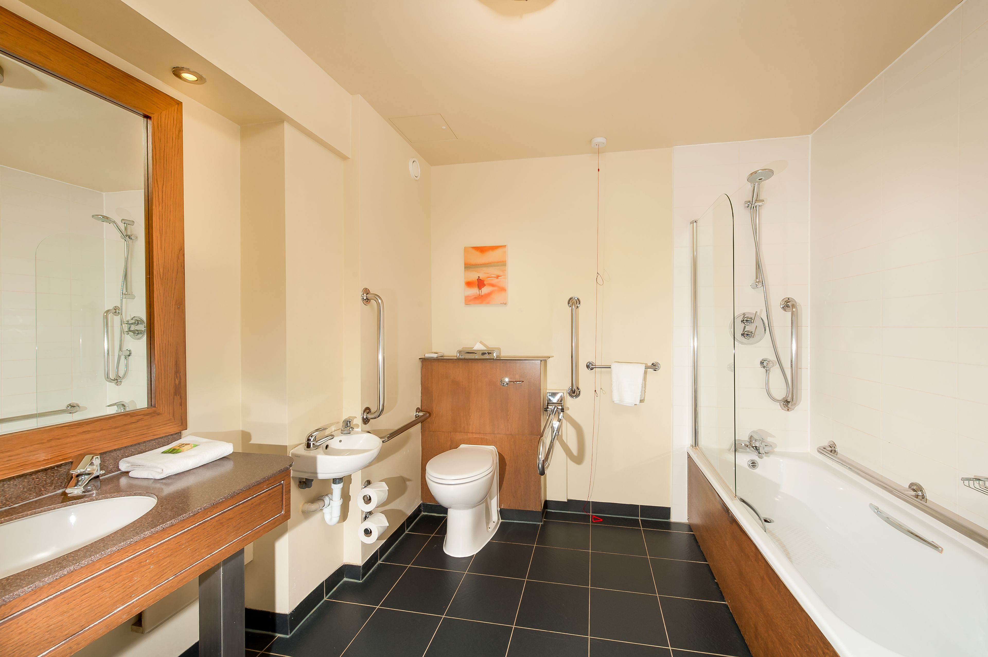 A modern bathroom with a sink, toilet, and bathtub.