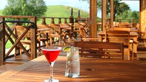 A wooden deck with outdoor seating and a table with two drinks. - Chessington Resort Hotel (Chessington)