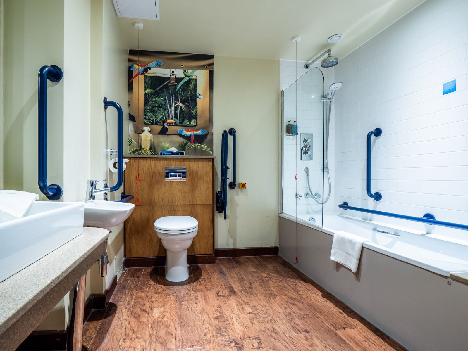 A bathroom with a toilet, sink, and shower area.