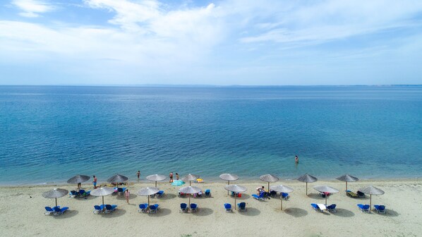 Na praia, espreguiçadeiras, toalhas de praia
