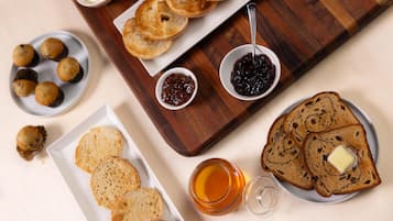Una tabla de madera con bagels, queso crema y mermeladas.