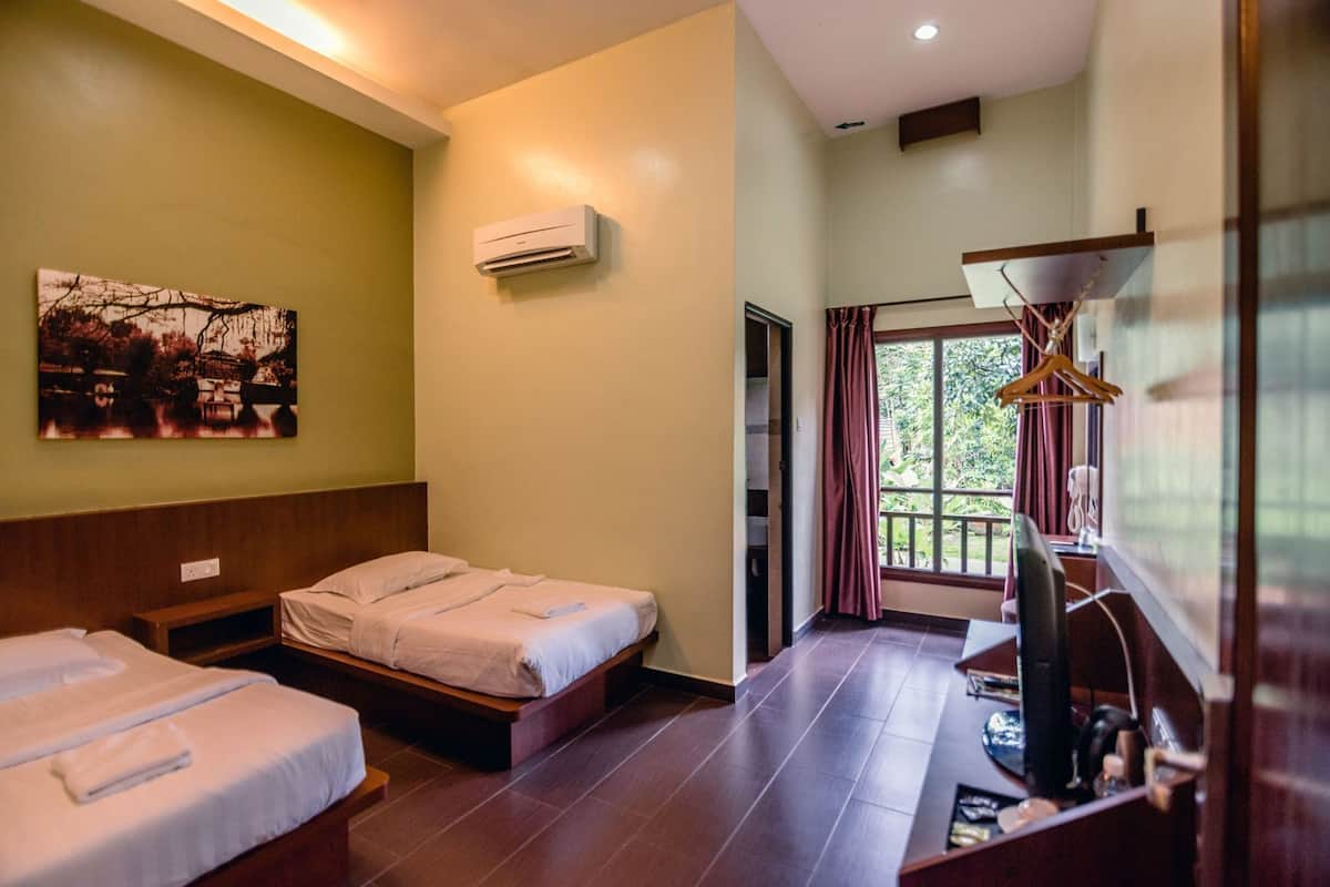 A hotel room with two beds, an air conditioner, a painting, a TV, and a window with curtains.