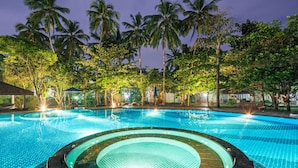A swimming pool with a circular hot tub area, surrounded by palm trees and lounge chairs. - Siddhalepa Ayurveda Resort - All Meals, Ayurveda Treatment, Yoga (Wadduwa)