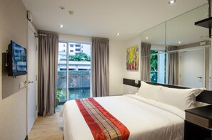 A modern hotel room with a large bed, a flat-screen TV, a large window with curtains, and a view of the outside. - 12FLY Hotel (Kuala Lumpur)