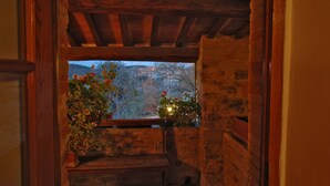 A stone staircase leading to a wooden balcony with a view of a mountainous landscape. - Albergo Il Colombaio (Castellina in Chianti)