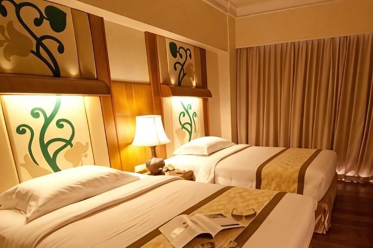 Une chambre d’hôtel avec deux lits, une table de chevet, une lampe et des panneaux décoratifs sur les murs.