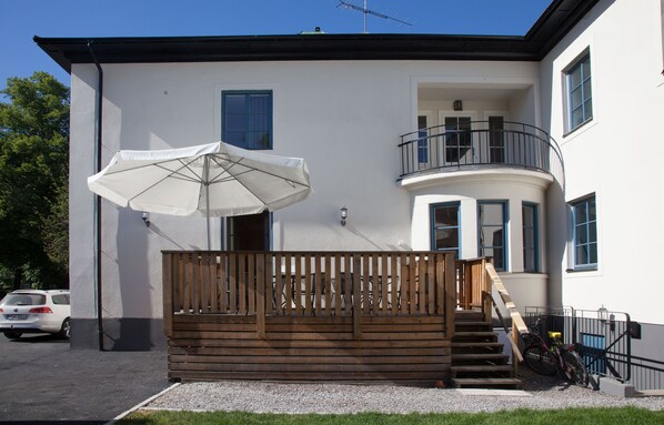 A two-story building with a balcony, a wooden fence, and a bicycle parked outside. - Södra Hotellet (Norrköping)