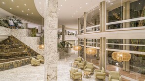 A spacious lobby with marble flooring, a staircase, and seating areas. - Hotel Maspalomas Princess-All Inclusive (San Bartolomé de Tirajana)