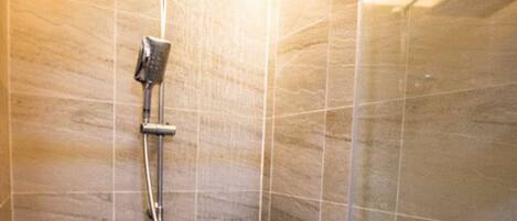 A modern shower with a handheld showerhead and a wall-mounted rain showerhead.