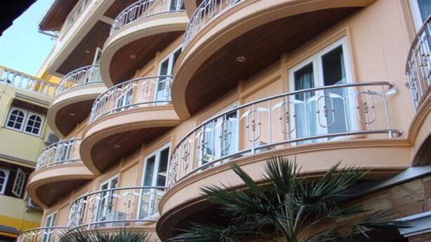 A multi-story building with balconies, each with metal railings and windows. - P72 Hotel (Pattaya)