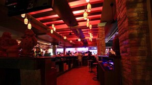An indoor bar with red lighting, hanging lanterns, and brick walls. - P72 Hotel (Pattaya)