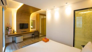 A modern hotel room with a bed, a desk, a television, and a shower area. - P72 Hotel (Pattaya)