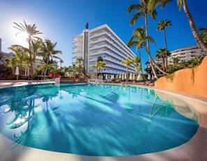A hotel with a large pool surrounded by palm trees and sun loungers. - Hotel Gran Canaria Princess - Adults Only (+16) (San Bartolomé de Tirajana)