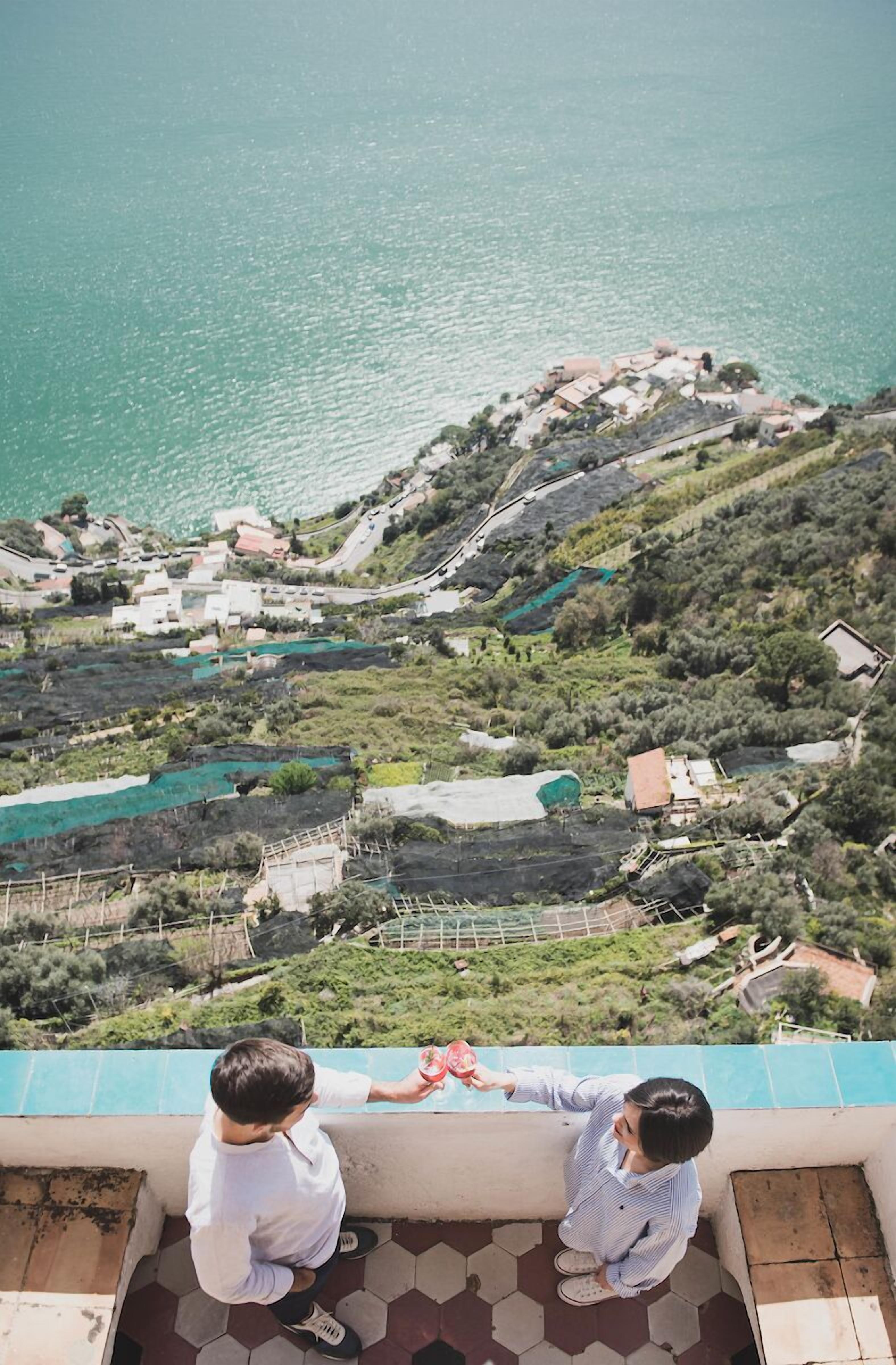 A terrace with a view of a coastal village and a body of water.