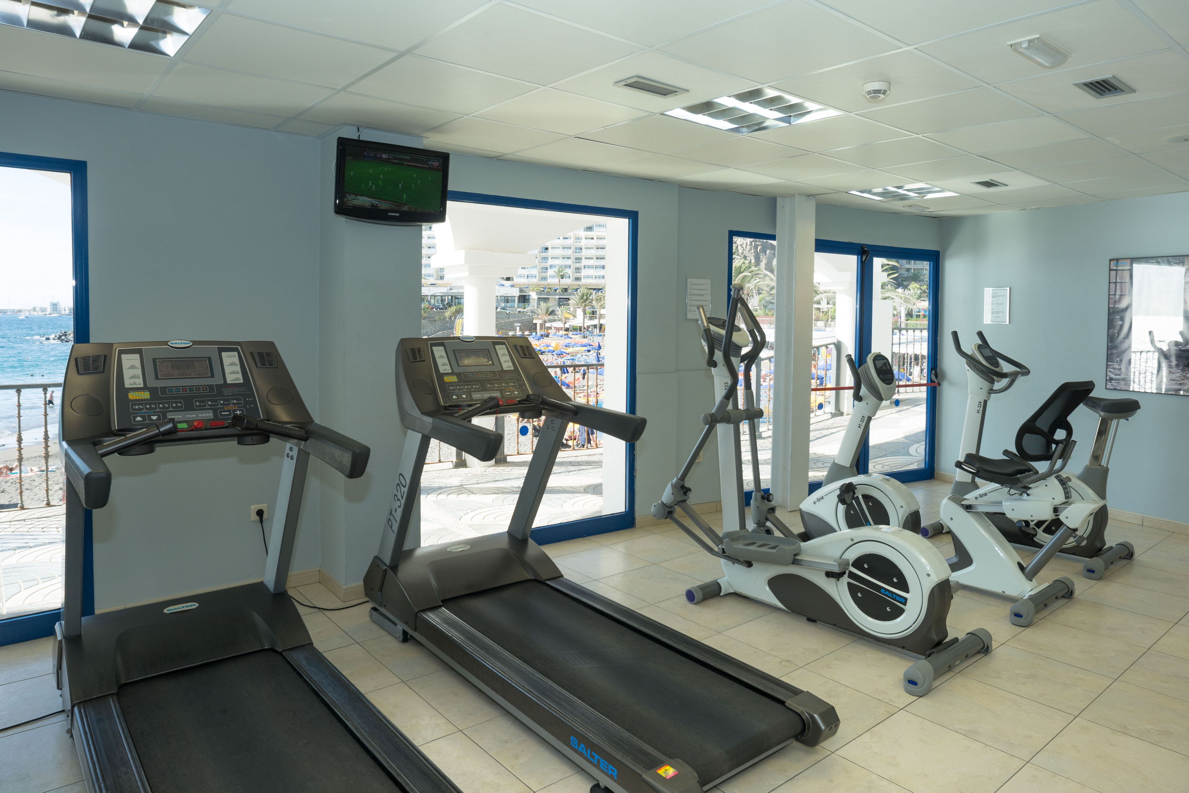 A gym with treadmills, elliptical machines, and stationary bikes.