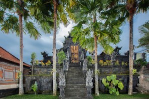 A temple entrance with stone steps, statues, and a traditional roof structure. - Alas Petulu Villa Resort and Spa (Ubud)