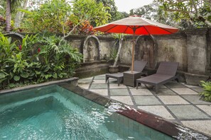 A pool area with a statue, lounge chairs, and an umbrella. - Alas Petulu Villa Resort and Spa (Ubud)