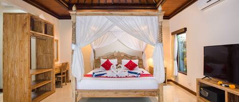 A four-poster bed with a canopy, a television, and a wooden cabinet.