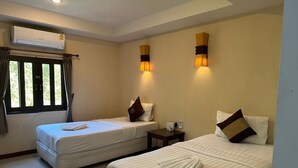 A hotel room with two beds, an air conditioning unit, a window with curtains, and wall-mounted lamps. - Baan Busaba Hotel (Ko Pha-ngan)