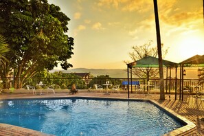 Een buitenzwembad en ligstoelen