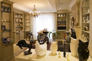 A well-lit room with a chandelier, shelves with decorative items, and a large panda statue.