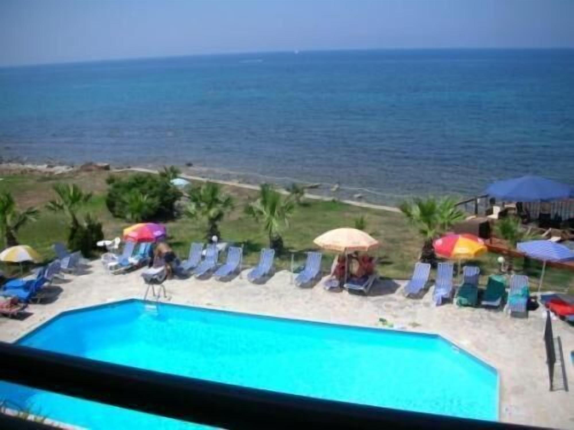 A poolside area with lounge chairs and umbrellas, overlooking a body of water.