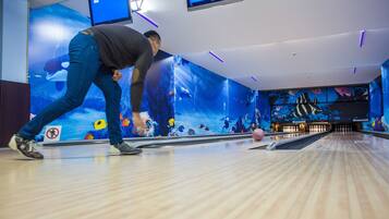 Une salle de bowling avec un plancher en bois et une piste de bowling.