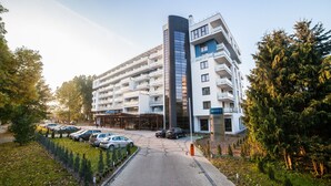 A modern multi-story hotel with a parking area in front. - Olymp 3 (Kolobrzeg)
