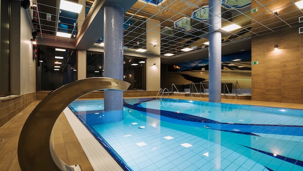 An indoor swimming pool with clear blue tiles, a modern design, and a central column. - Olymp 3 (Kolobrzeg)