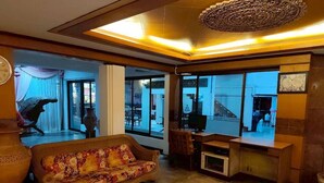 A living room with a sofa, a television, and a large window. - Dream Hotel Pattaya (Pattaya)