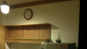 Una cocina con armarios de madera, un refrigerador y un reloj en la pared.