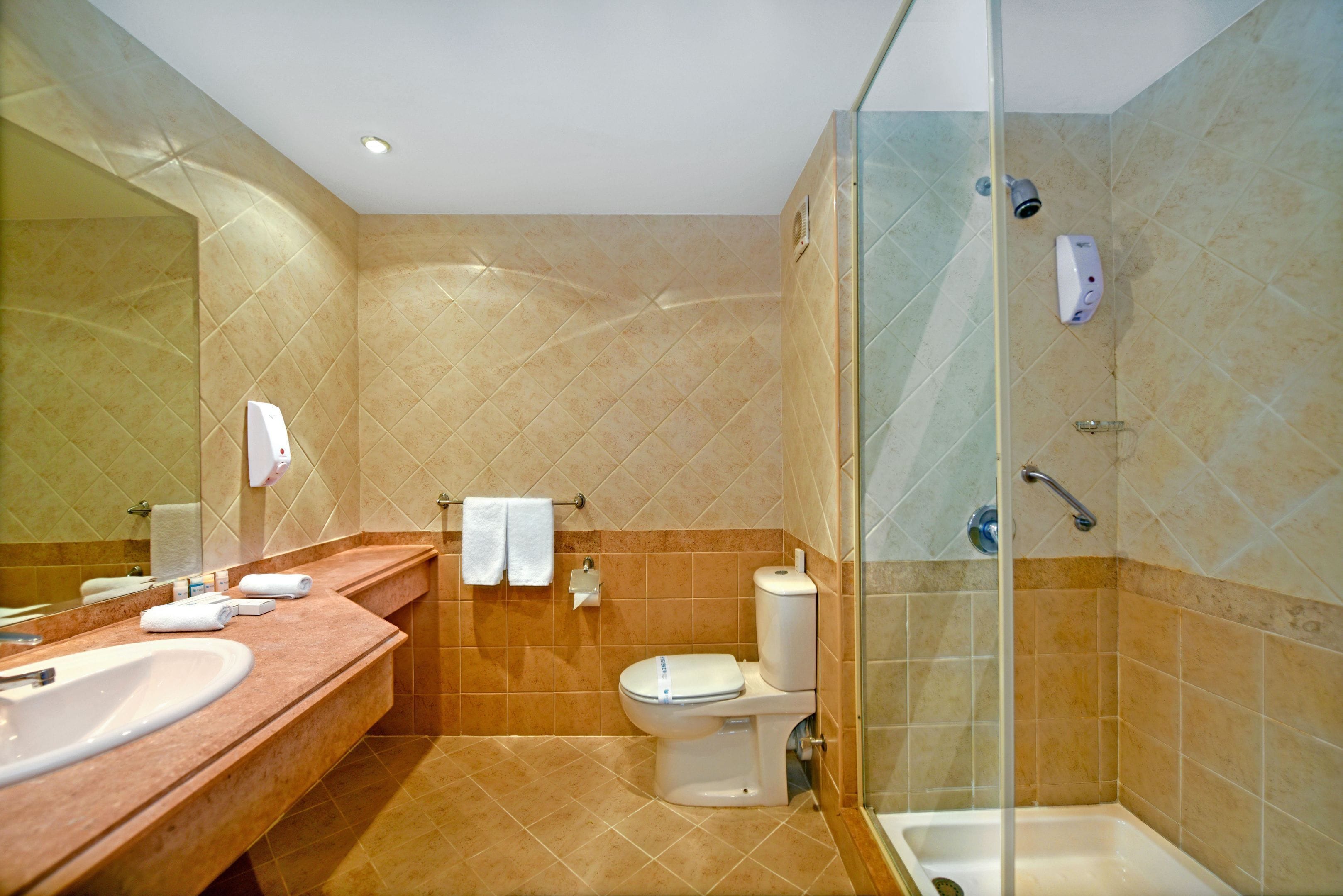 A bathroom with a sink, toilet, and shower.