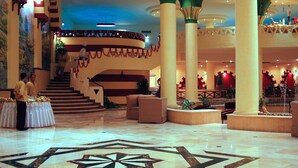 A spacious lobby with a grand staircase, high ceilings, and a decorative fountain. - Bliss Nada Beach Resort (Marsa Alam)