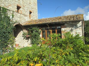 A stone building with a tiled roof, arched windows, and a small balcony. - Relais Villa Casalta (Castellina in Chianti)