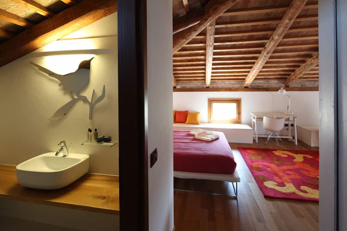 Un dormitorio con cama, escritorio y silla.