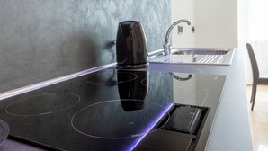 Una cocina moderna con una vitrocerámica negra elegante, un grifo de acero inoxidable y un horno empotrado.