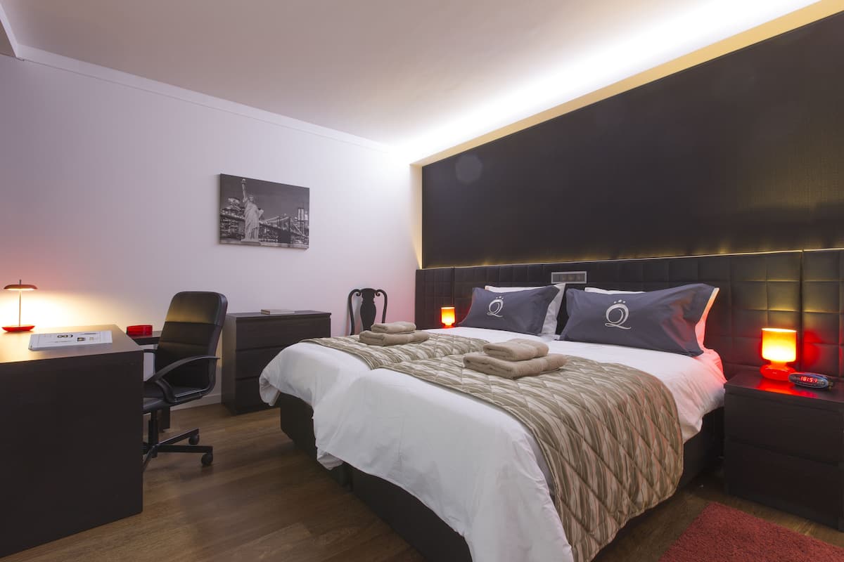 Ein modernes Hotelzimmer mit einem großen Bett, einem Schreibtisch und einem Stuhl.