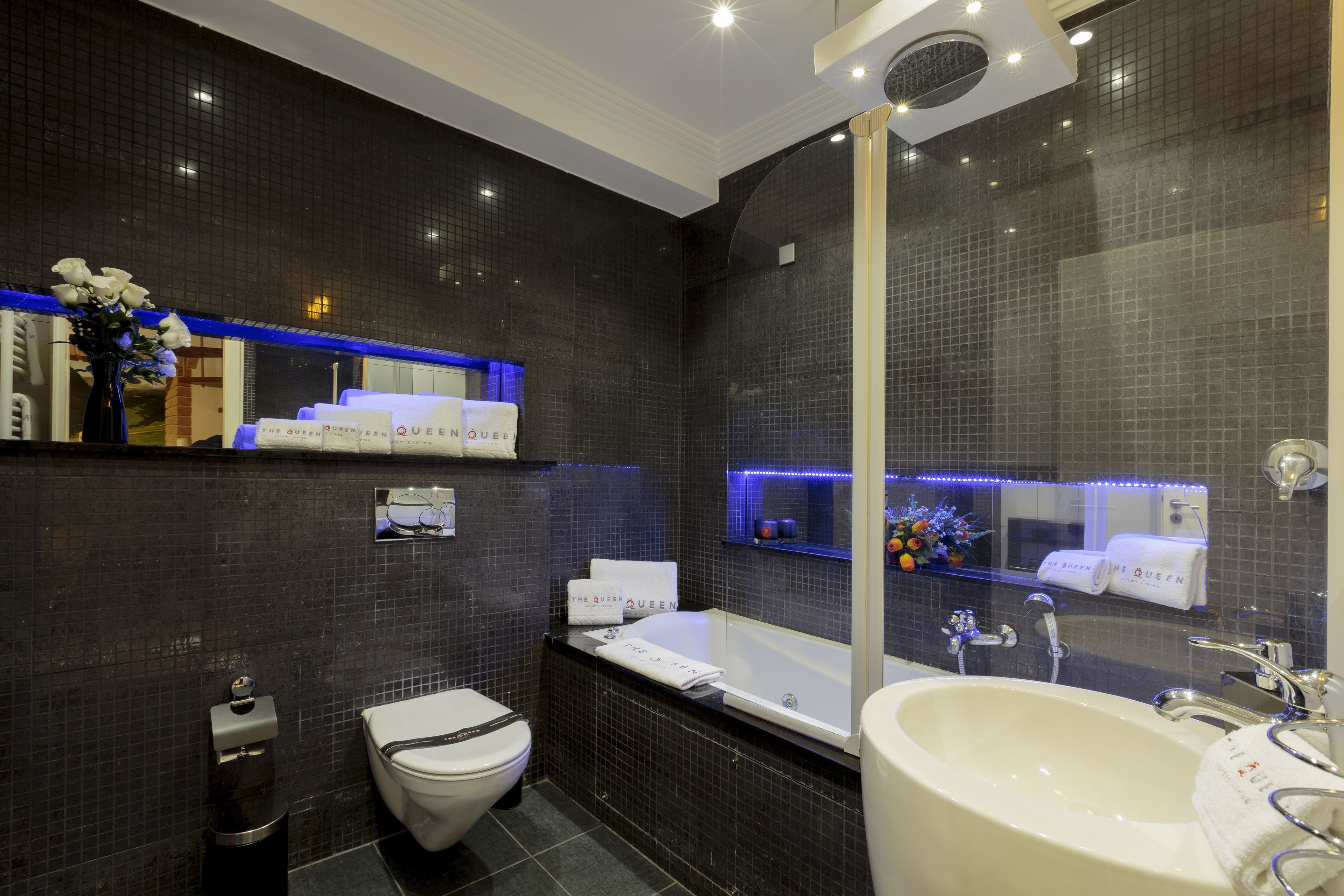 A modern bathroom with a bathtub, a large sink, and a toilet.