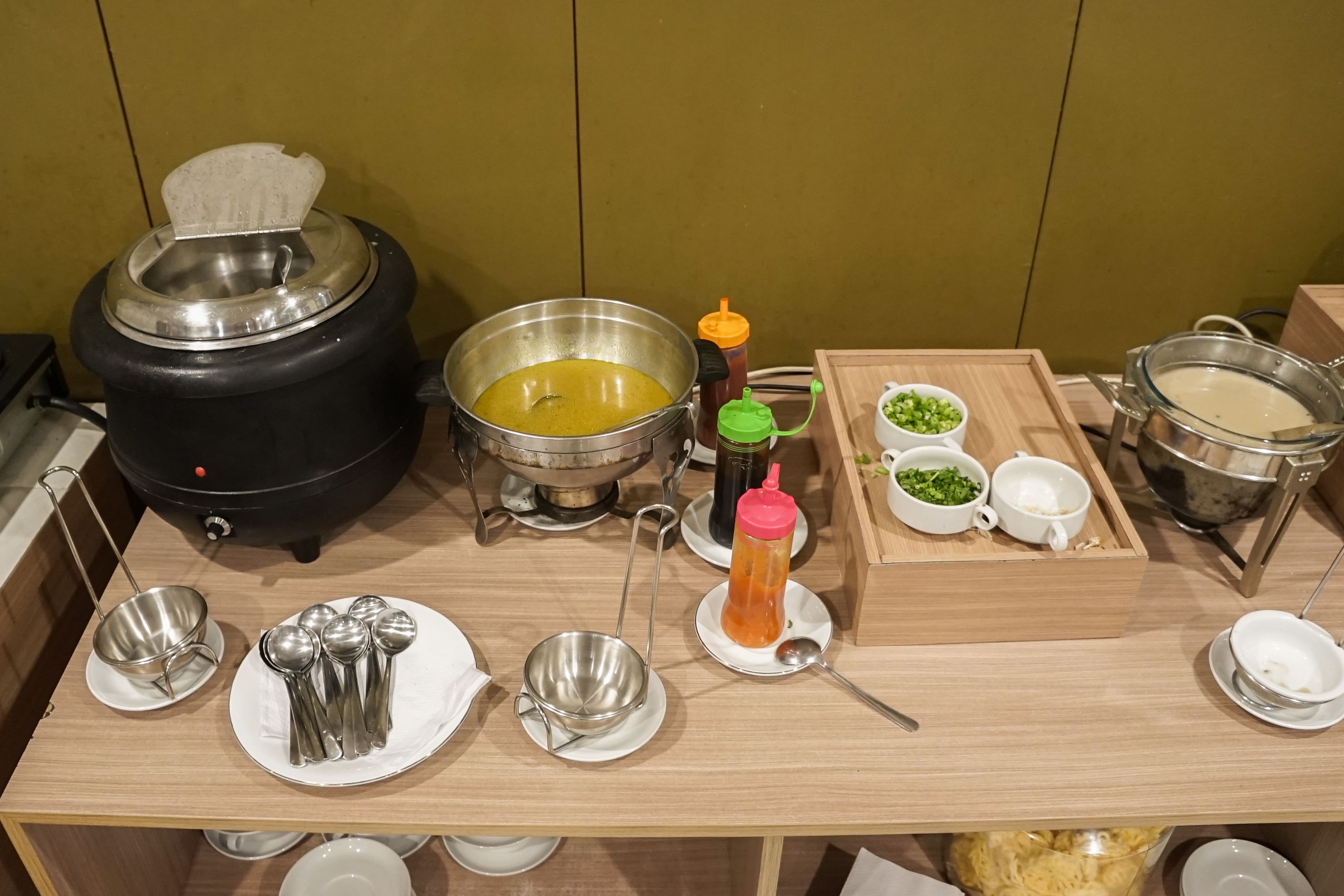 A kitchen counter with various cooking utensils, pots, and containers.