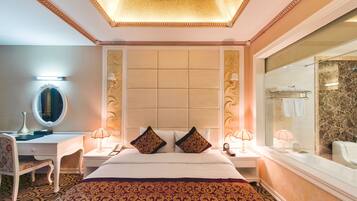 Una habitación de hotel con una cama grande, un escritorio con espejo, dos lámparas de noche y un espejo grande en la pared.