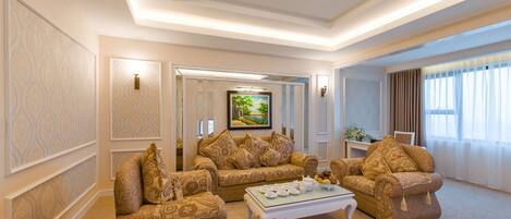 A spacious living room with a beige carpet, patterned sofas, a coffee table, and a painting on the wall.