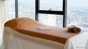 Enjoy a panoramic city view from the comfort of this stylish room, featuring a large window and a neatly made bed.