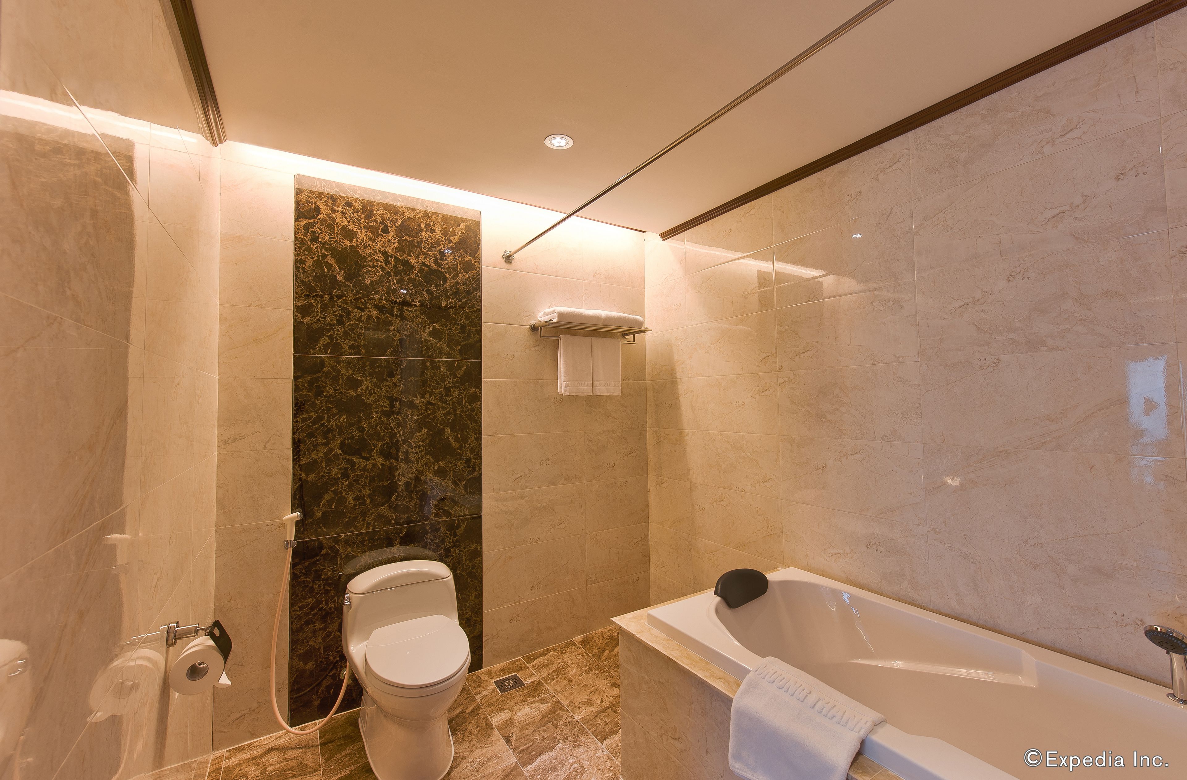 A modern bathroom with a toilet, shower, and bathtub.