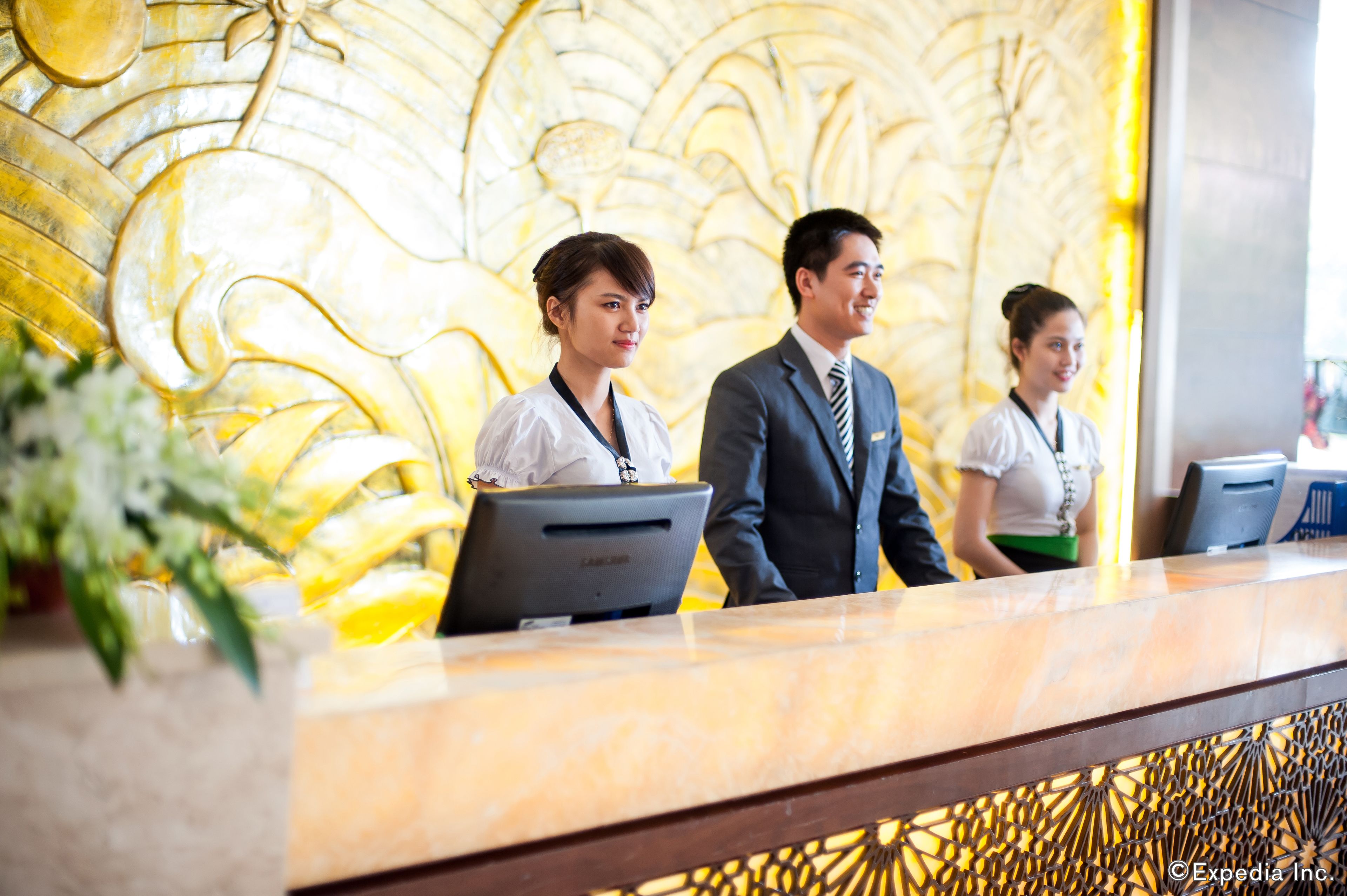 A reception desk with a marble top and a decorative wall in the background.