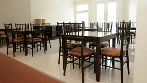 A dining area with a large table and multiple chairs. - SofyanInn Srigunting (Bogor)