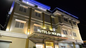 A multi-story hotel with a prominent entrance and illuminated signage. - Rangkayo Basa Halal Hotel (Padang)